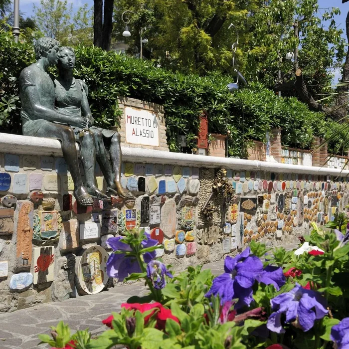Il Muretto di Alassio con la statua degli innamorati e le ceramiche dei personaggi famosi